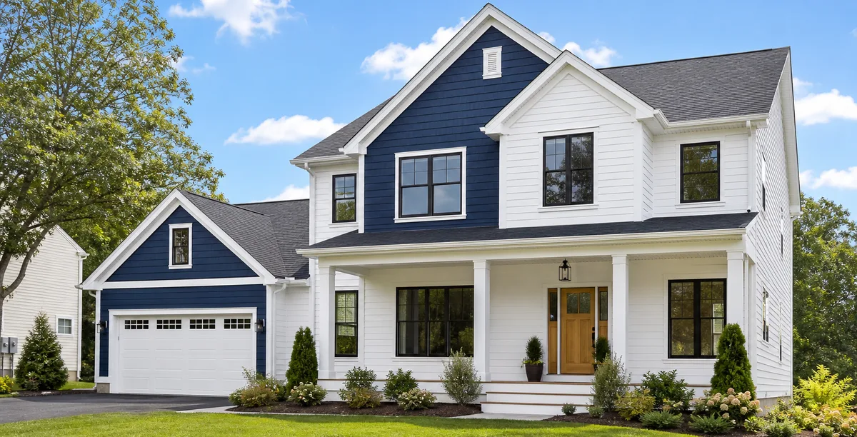 The same two-story home after a white and navy exterior paint transformation.
